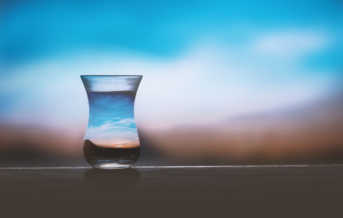 стакан воды на фоне неба