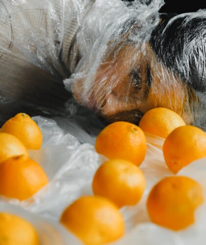 девушка в пленке с апельсинами