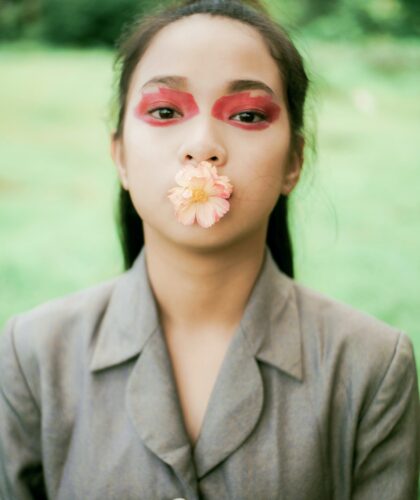 девушка с цветком во рту