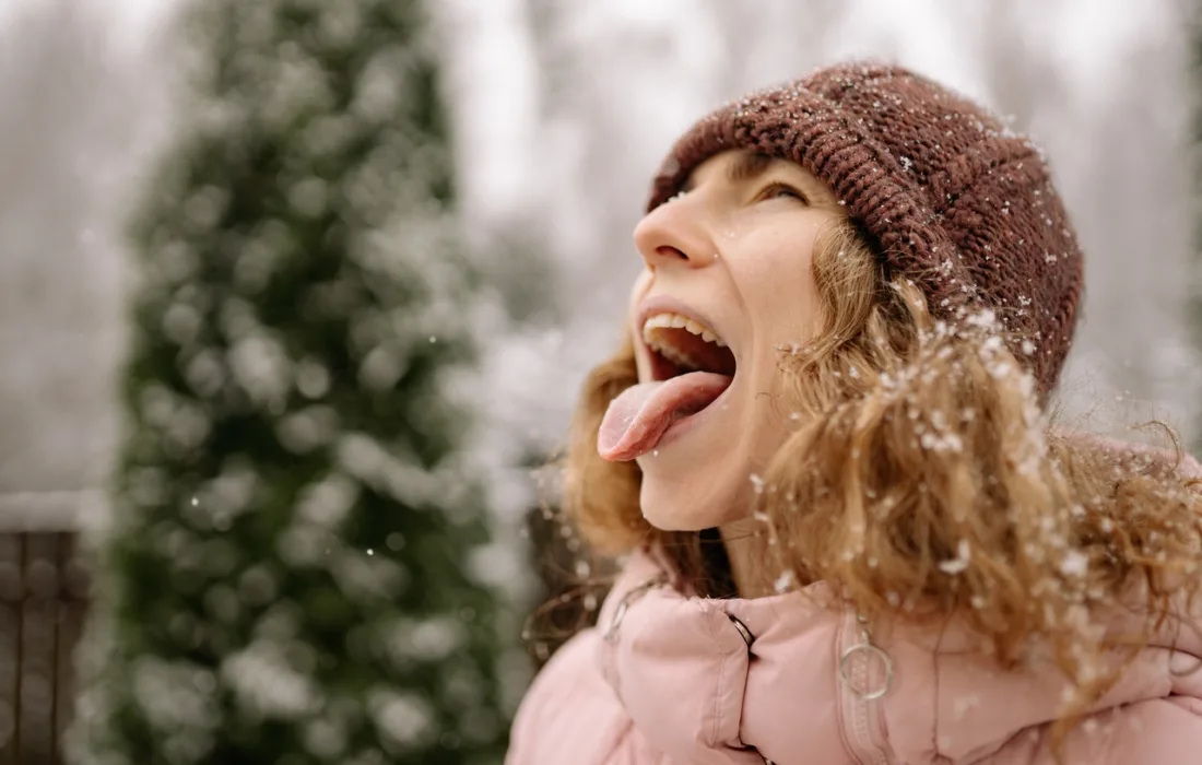девушка ловит снежинки языком