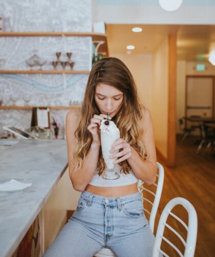 девушка пьет кофе с топпингом