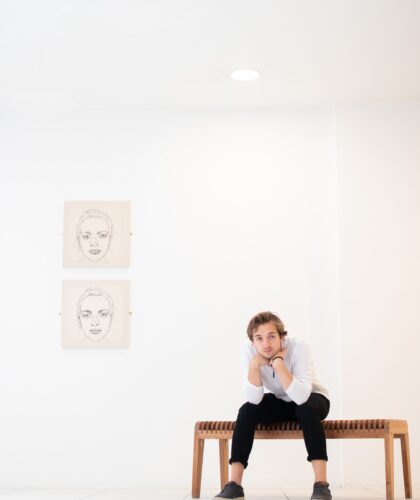 Мужчина сидит рядом с картинами