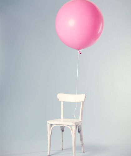 розовый шарик на белом стуле